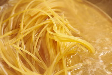 Boil pasta noodles in boiling water