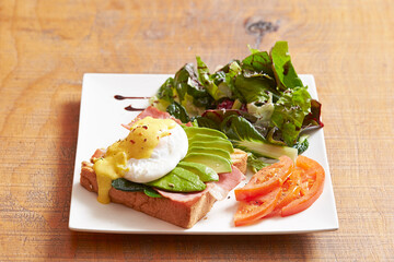 Avocado open sandwich and salad on plate