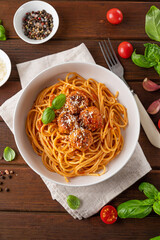 Traditional Italian spaghetti pasta with meatballs, tomato sauce and parmesan cheese, selective focus. Comfort food.