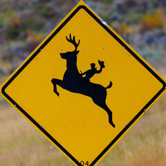 Deer crossing sign in western Wyoming with a cowboy riding the deer.