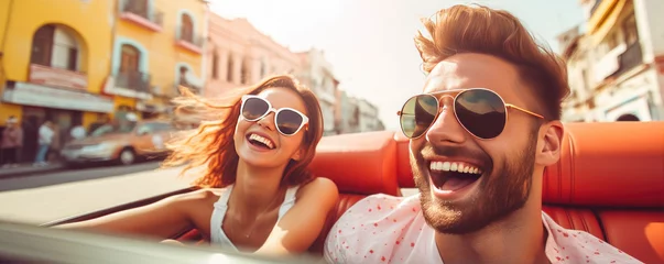 Foto op Canvas Happy young couple is enjoying ride in a cabriolet car during summer sunny day, active lifestyle concept © Filip