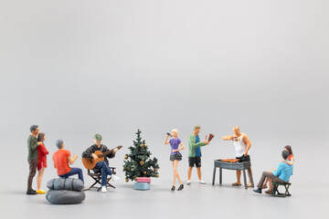 Miniature Families are joyfully celebrating and dining together.  Concept of a Merry Christmas