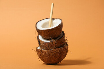 Coconuts with straw on beige background, close up