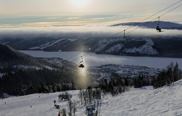 Ski lift in operation against a backdrop of white clouds and a picturesque landscape in Are, Sweden