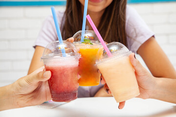 Friends holding drinking together fruity slush drinks. - Powered by Adobe