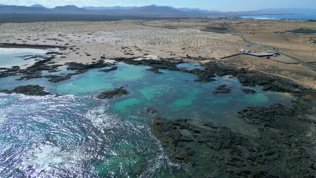 Aerial orbital clip of the natural pools and volcanic rock formations near El Cotillo in Fuerteventura Spain