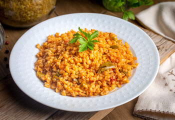 Traditional turkish bulgur pilaf with tomato sause in plate (Turkish name; meyhane pilavi)