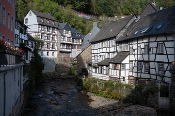 View of houses and streets of old colourful German town Monschau in bend of the river and hidden between the hills, Eifel national park, Germany