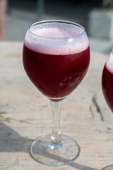 Famous fresh brewed red lambic kriek cherry beer served outside in Belgian beer festival in Durbuy,  special Belgian beer glass in sun lights