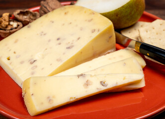 Piece of Dutch Gouda cheese made from cow milk with added walnuts close up