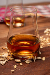 Tasting of different Scotch whiskies strong alcoholic drinks, drum of whiskey and colorful Scotch tartan on background close up