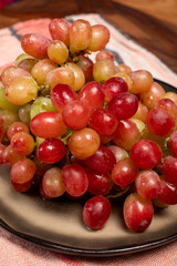 Sweet washed ripe pink grapes berries on board ready to eat