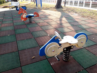 Selective focus, colorful park children playground. Plastic rocking horse