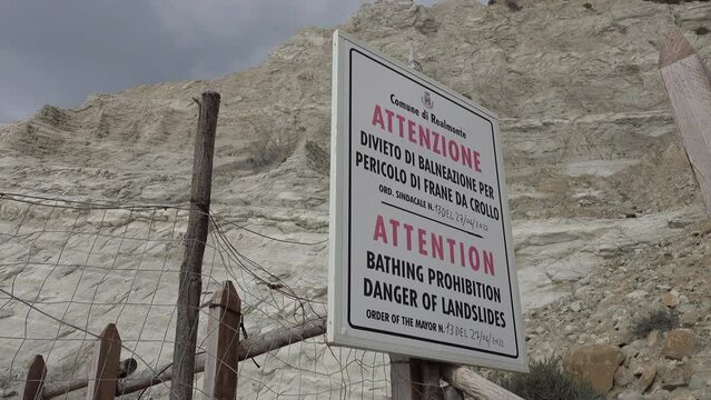 Warning sign for landslides (and forbidden to bath) at entrance to Scala dei Turchi, a series of surreal rock formations in Sicily Italy
