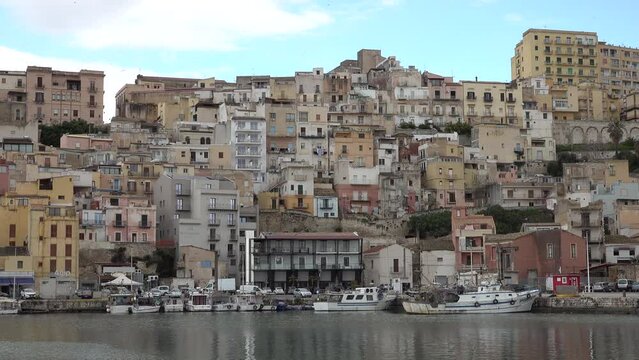 Fishing harbor and skyline of colorfully painted houses in Sciacca, an important commercial port on Sicily, Italy
