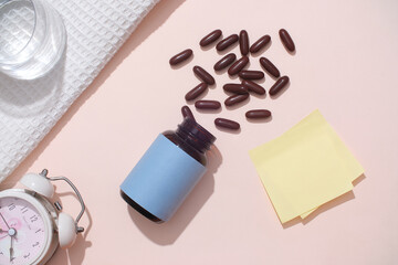 Brown capsules are poured onto the table from an unlabeled pill bottle with some props on a pastel background. Copy space for drug advertising. Treat the disease with medicine.