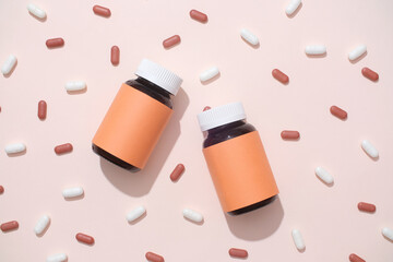 Close-up of two unbranded medicine bottles placed on a background with white and red tablets....