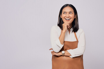 Smiling young Asian woman barista barman employee wearing a brown apron working in coffee shop...