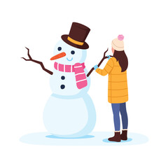 little girl in warm clothes makes a snowman with a carrot nose, scarf and top hat