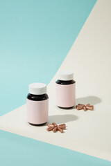 Close-up of two unlabeled medicine bottles with hard capsules displayed in the background. The...