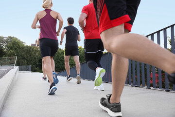 Fototapeta premium Group of people running outdoors, back view