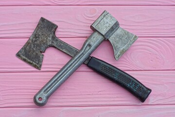 two different iron old sharp hand industrial small dangerous rusty hatchets for chopping wood lie...