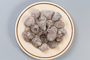 Dried figs on saucer, top view on a gray background