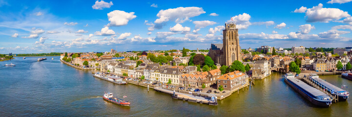 Panoramic view of Dordrecht Netherlands the skyline of the old city of Dordrecht with a church and canal buildings in the Netherlands.  - obrazy, fototapety, plakaty