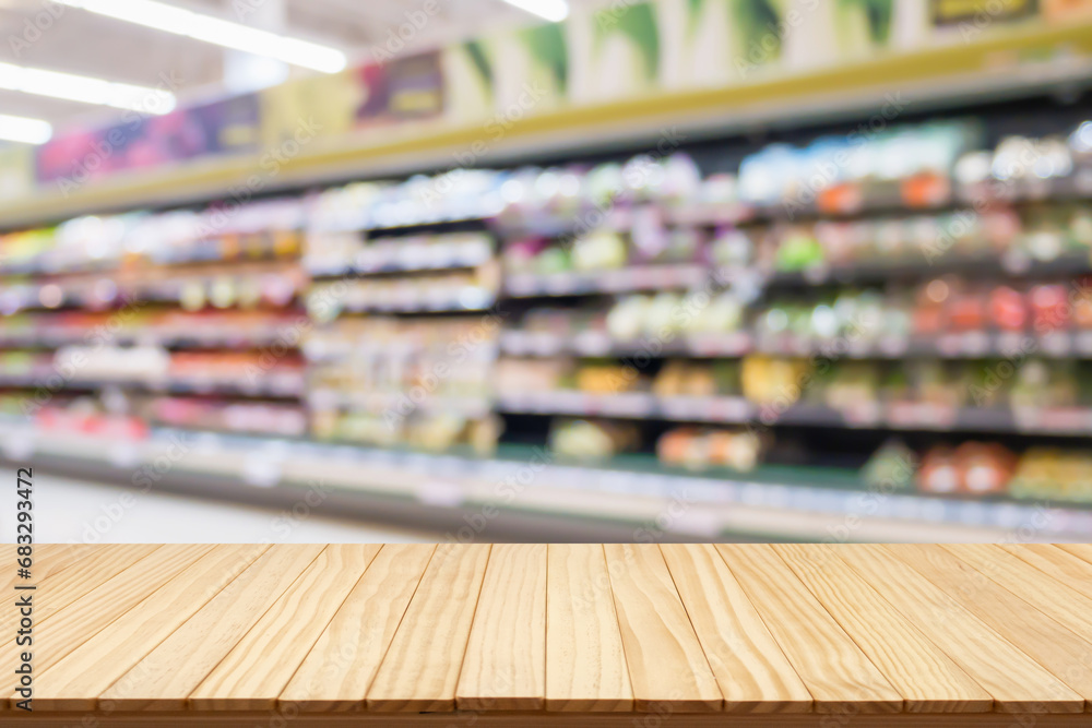 Wall mural empty wood table top with supermarket blurred background for product display