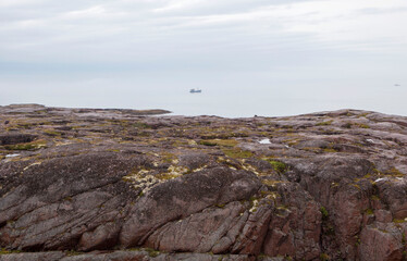 Rocks extending into the vastness of the Barents Sea. Rural settlement Teriberka. Kola district, Murmansk region. Russia