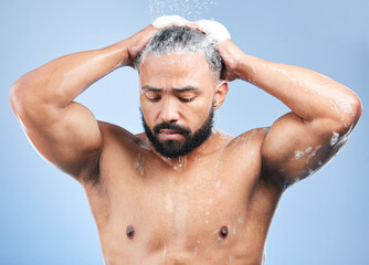 Shower, washing hair and man with water in studio for cleaning, hygiene and skincare on blue...
