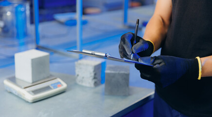 Engineer working in industry lab for testing building materials. Controls size and quality of...