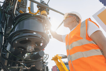 Hydraulic engineer doing safety check on new installation hoses of modern drilling industrial...