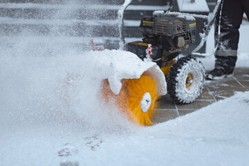 a man cleans snow in winter with a snow blower after a snowfall, equipment for snow removal