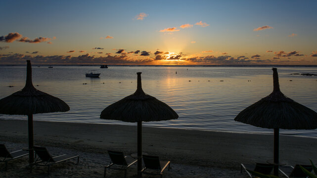 Early morning sunrise beyond the beach umbrellas Solana Beach in Mauritius 