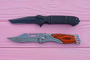 two different iron sharp open  folding dangerous new gray and black military industrial modern with...