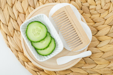 Cucumber slices and wooden hairbrush (comb) for preparing homemade hair toner or facial mask....