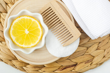 Lemon fruit slice and wooden hairbrush for preparing homemade hair mask, face toner or eye mask. Natural beauty treatment and spa recipe.