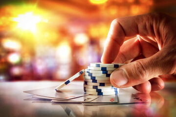 Hand betting with chips with ace cards in gambling hall