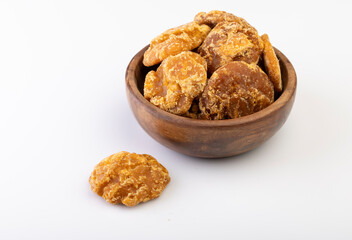 A close-up shot of jaggery neatly placed in a bowl against a clean white background