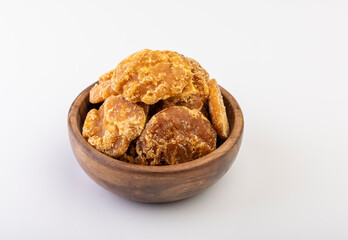 A close-up shot of jaggery neatly placed in a bowl against a clean white background