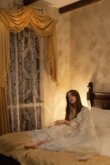 a young princess girl sits on her vintage bed in a castle