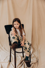 a little girl of 6 years poses for a photo in a photo studio, changing different emotions and poses