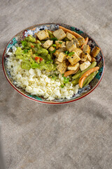 Vibrant cauliflower 'rice' bowl with marinated tofu, colorful pasta, and creamy avocado guacamole. A colorful, healthy feast!