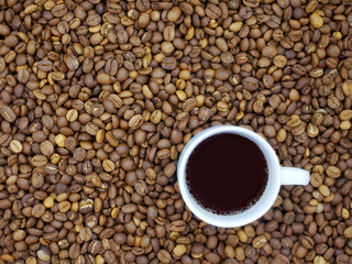 Coffee cup on coffee beans texture background.Top view.