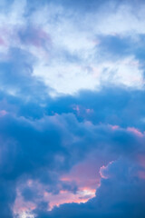 Blue morning sky with pink clouds. Sunrise clouds are in vanilla colours. Beauty in nature. Twilight time, golden hour. Details of evening sunset. Natural abstraction. Peace concept. Vertical view