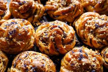 Sweet cardamom rolls sprinkled with chopped nuts and dried cornflower petals,  focus on the bun inside. Homemade sweet baked goods