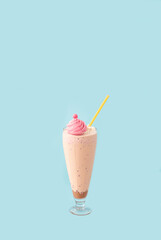 
Ice cream milkshake in glass cup on light blue background