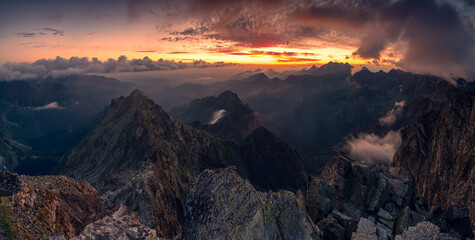 Sunrise at Rysy peak in Tatra Mountains with rocky foreground. Colofrul sky with clouds in early morning. Slovaki and Poland border at the top. - obrazy, fototapety, plakaty