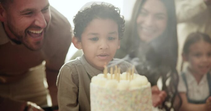 Child, candles and blow at birthday cake with family love at Jewish celebration, party together for son development. Parents, boy and kippah hat for youth dessert or sweet sugar, happy for eating